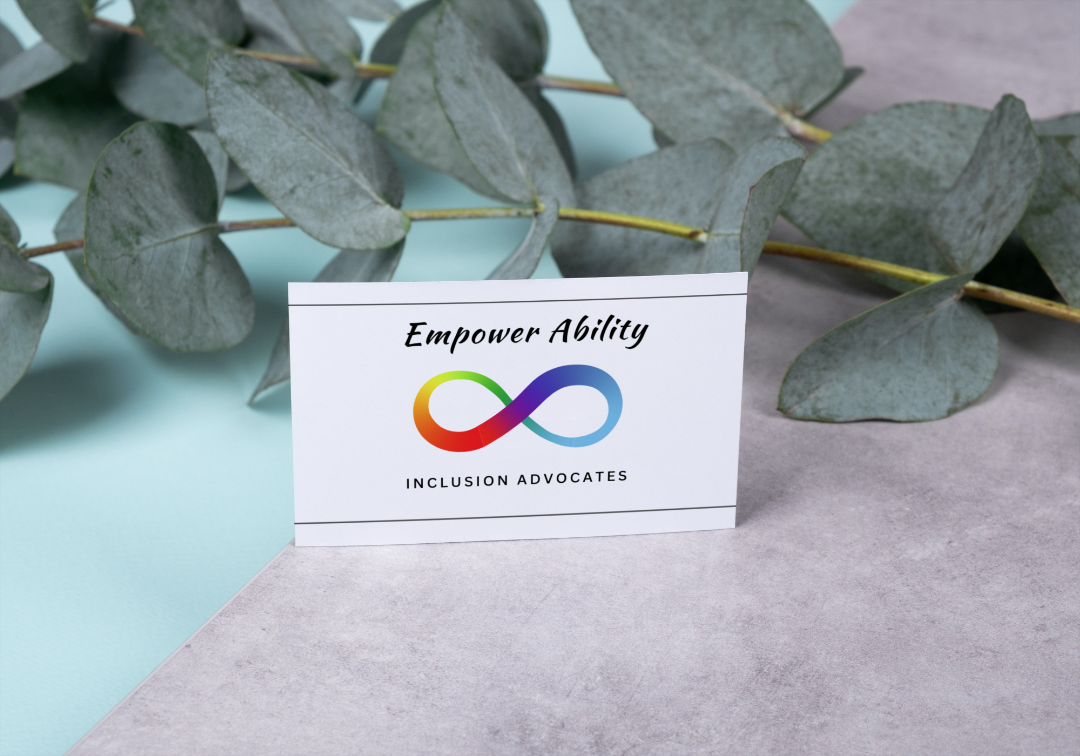 White Business Card on a gray surface near foliage.