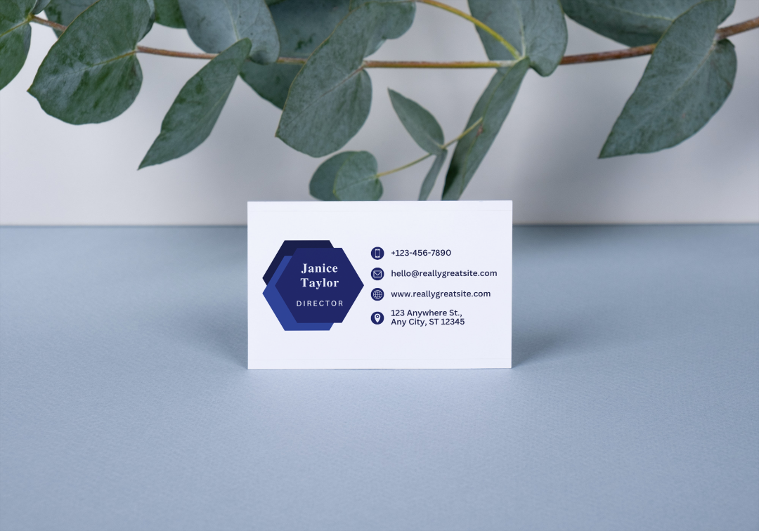 Dark Blue Business Card on a gray surface near foliage.