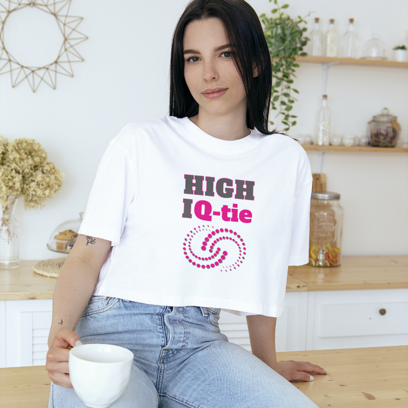 Woman sitting on a counter, holding a mug, wearing a cropped T-shirt