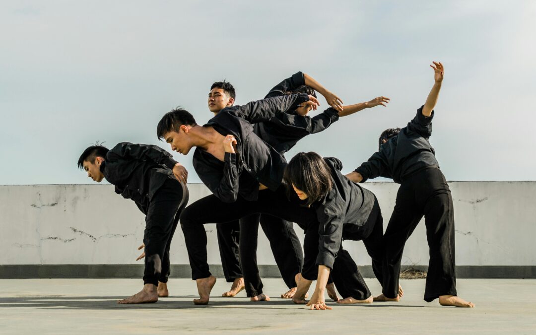 photo of six people in black matching clothes dancing at daytime